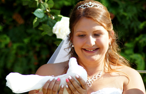Hochzeitsfotograf Dresden - natürliche Hochzeitsfotografie aus Dresden, Foto einer glücklichen Braut mit einer Indischen Pfauentaube und Hochzeitstauben Dresden